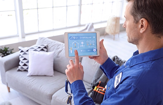 Tempo Air HVAC technician using a tablet to review smart thermostat settings inside a residential apartment.