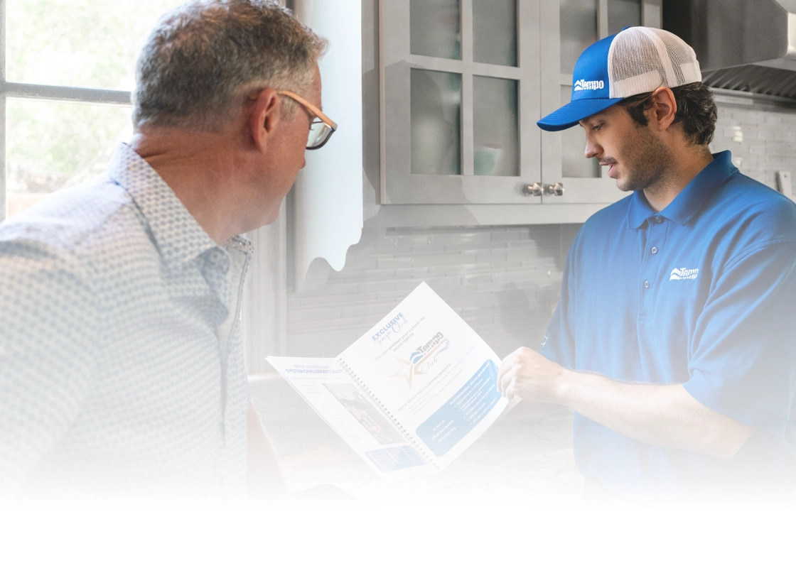 Tempo Club Comfort Advisor reviewing HVAC service documentation with a homeowner in their kitchen